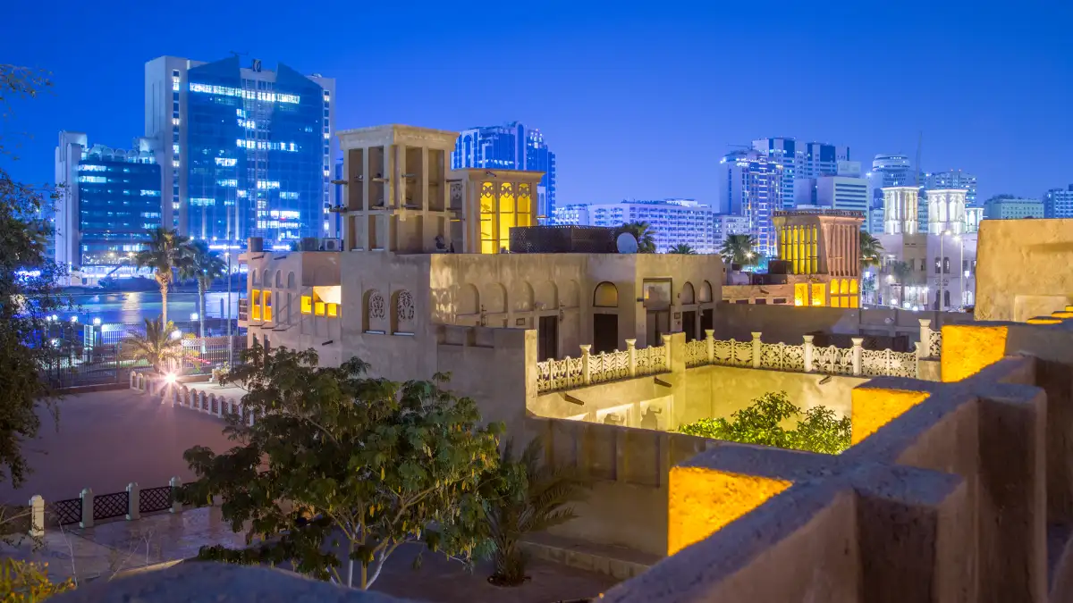 حیاط و کوچه‌های محلهٔ تاریخی الفهیدی با بادگیرهای سنتی در نور عصر